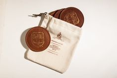 two brown leather coasters sitting on top of a white bag