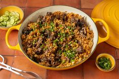 a large pot filled with food next to two smaller bowls