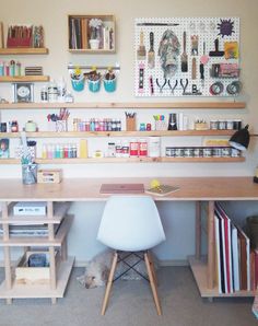 there is a desk and shelves in the room with many items on display above it