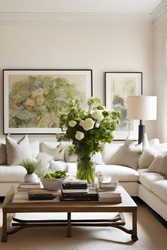 a living room with white furniture and flowers on the coffee table in front of it