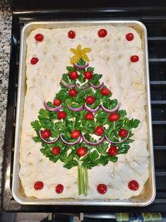 a christmas tree made out of vegetables on top of a cookie sheet in an oven