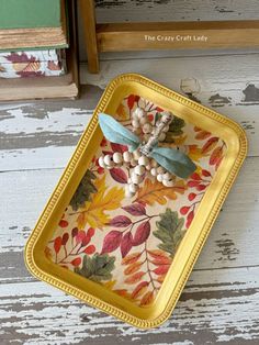 a yellow tray with beads and leaves on it