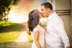 a man and woman kissing each other while covered in paint