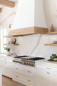 a stove top oven sitting inside of a kitchen next to white cabinets and counter tops