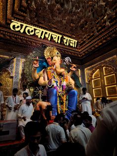 there is a statue of the god ganesh in front of people gathered around it