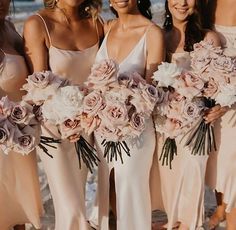 a group of women standing next to each other holding bouquets