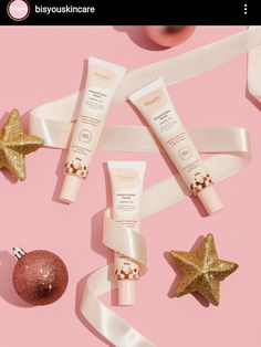 three different types of skin care products on a pink background with gold stars and ornaments