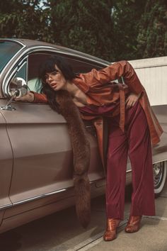 a woman leaning on the door of a car