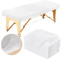 a stack of white sheets sitting on top of a wooden table next to a pile of folded