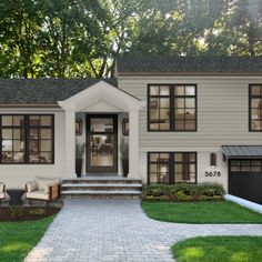 We love how this door makes a statement on the front of the house and pops beneath the portico. The openness from the glass panes and side panels really make the house look more warm and welcoming. We used these modern Cylinder sconces that we flanked against the garage to light this space in a great way. We also added these very traditional McGee & Co fixtures in the entry to additional interest and to pull the eye to the focal point Brick Split Level Exterior Makeover, Raised Ranch Remodel Exterior, Colonial House Exterior Design, Exterior Transformations, Exterior Colonial House, House Exterior Colonial, Modern Colonial House Exterior, Colonial House Exterior, Split Level House Exterior