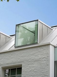 a white building with two windows and a skylight