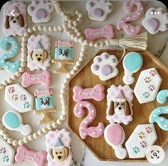 decorated cookies are arranged on a tray with decorations and numbers for the baby's first birthday