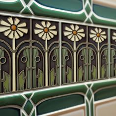 an art deco tile design with flowers and leaves on the border, in shades of green