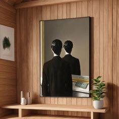 two people standing in front of a mirror on a shelf next to a potted plant