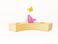 a wooden toy sitting on top of a piece of wood