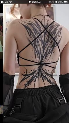 the back of a woman's body with tattoos on her upper and lower torso