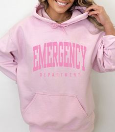 This ER Nurse Hoodie / Emergency Department Sweatshirt is perfect for the Emergency Nurse, ER Doctor, ER Tech - anyone who works in the ER Department!  **UNISEX SIZING**  ♥ W E L C O M E  T O  S K E T C H Y  C A T  D E S I G N S ! ♥ See more Emergency Department designs here: https://etsy.me/3VsWA9T Click here to return to our shop's home page ⇒ https://www.etsy.com/shop/SketchyCatDesigns Say hello to your new favorite sweatshirt! All of our products are printed with eco-friendly water-based inks, giving them the softest feel. The design itself is embedded into the fabric so that your shirt is cozy and comfy and has an already washed look. They look amazing sized up as well. We love that lived-in look! P R O D U C T  *  Unisex Sizing - Relaxed Fit  *  50/50 cotton + polyester  *  Medium th Emergency Nurse Tattoo, Pink Crew Neck Outerwear With Letter Print, Pink Crew Neck Hoodie For College, Pink Letter Print Hoodie For College, Pink Drawstring Hood Sweatshirt For College, Nurse Fashion, Er Tech, Er Doctor, Nurse Crewneck