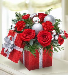 a red present box with silver ornaments and flowers