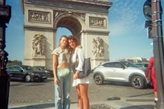 two young women standing in front of the arc de trioe triumph gate, paris