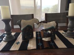 the table is set with candles and figurines on top of striped rugs