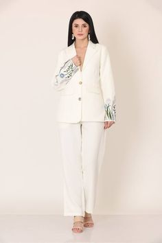 White blazer with floral placement embroidery on the sleeves. Paired with a pant. - Aza Fashions Embroidery Blazers For Women, Tailored Spring Pantsuit With Straight Pants, Spring Tailored Pantsuit With Straight Pants, Fitted Floral Embroidery Pants For Fall, Tailored Floral Embroidered Blazer For Spring, Fitted Floral Embroidery Blazer For Work, Tailored Embroidered Blazer For Workwear, Elegant Embroidered Blazer For Work, Elegant Embroidered Spring Suits