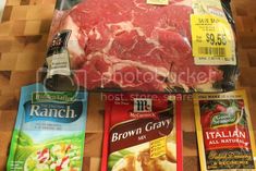 some meat and seasonings are on a wooden table next to bags of ranch mix