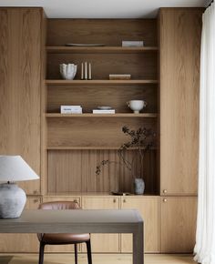 a table with a lamp and some books on top of it in front of a bookcase