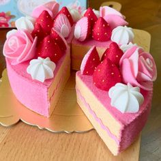 two pieces of cake with pink frosting and strawberries on top