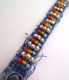 a close up of a piece of cloth with beads on it and a button in the middle