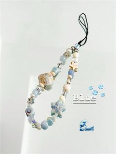 a necklace with shells and beads hanging from it's side on a string that says blue