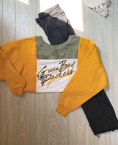 "NFL Green Bay Packers color-block Crewneck Rework  Style: Crewneck Colors: Green, yellow, & white. Graphic: NFL Green Bay Packers Size: Best fitting MEDIUM  Measurements are all taken laying flat Pit to pit: 24\" Length: 23\" Model pictured is xs-s, 5'2 for reference This is a sustainable, 1 of 1 product that was upcycled & handcrafted by 2nd hand material.  Madsew'n ♻️ Instagram & TikTok: Madsew.n Fb page: Madsew'n" Yellow Patchwork Crew Neck Top, Yellow Color Block Sweatshirt For Fall, Casual Yellow Tops With Splicing, Yellow Color Block Long Sleeve Top, Casual Yellow Spliced Top, Yellow Long Sleeve Patchwork Tops, Yellow Long Sleeve Top With Contrast Color, Long Sleeve Yellow Patchwork Tops, Yellow Color Block Cotton Sweatshirt