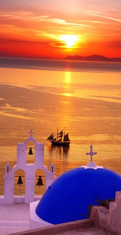 the sun is setting over an ocean with small boats