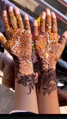 two hands with henna designs on them