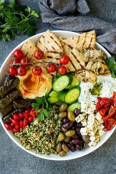 a white bowl filled with different types of food and vegetables on top of a table