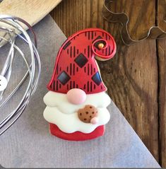 a cookie shaped like santa claus with a cookie in his hand on top of a table