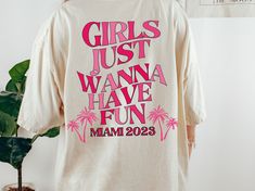 a t - shirt that says girls just wanna have fun on it, next to a potted plant