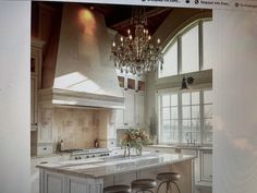 an old photo of a kitchen with chandelier above the island and two bar stools