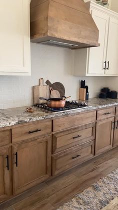 a kitchen with wooden cabinets and marble counter tops