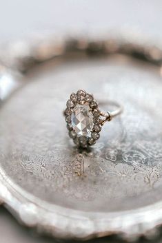 a diamond ring sitting on top of a silver tray