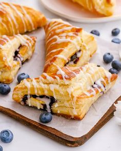 blueberry croissants with icing on a cutting board