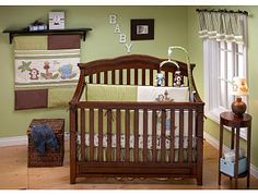 a baby crib in the corner of a room with green walls and wooden floors