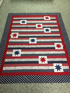 a red, white and blue quilt on the floor