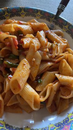 a plate filled with pasta and vegetables on top of a table