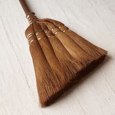 four wooden brooms sitting on top of a white blanketed floor next to each other