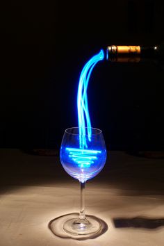 an image of a wine glass with blue light coming out of the top and bottom