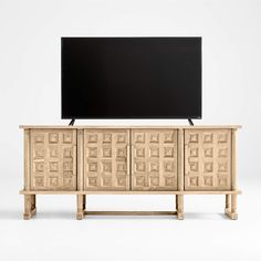 an entertainment center with a flat screen tv mounted on it's sideboard, in front of a white background