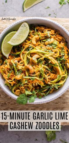 a white bowl filled with noodles and garnished with cilantro, parsley and lime