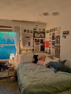 a bedroom with pictures on the wall and a bed in front of a large window