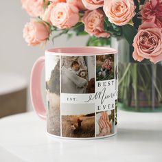 a pink coffee mug sitting on top of a white table next to flowers and a vase