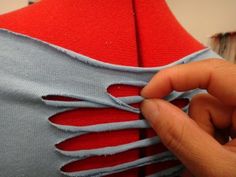 someone is stitching the back of a dress with red and blue fabric on it